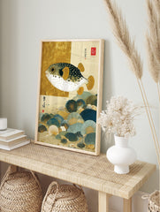 Japanese illustrative print of a pufferfish with gold fins swimming over blue and gold, in an alternate framed mockup