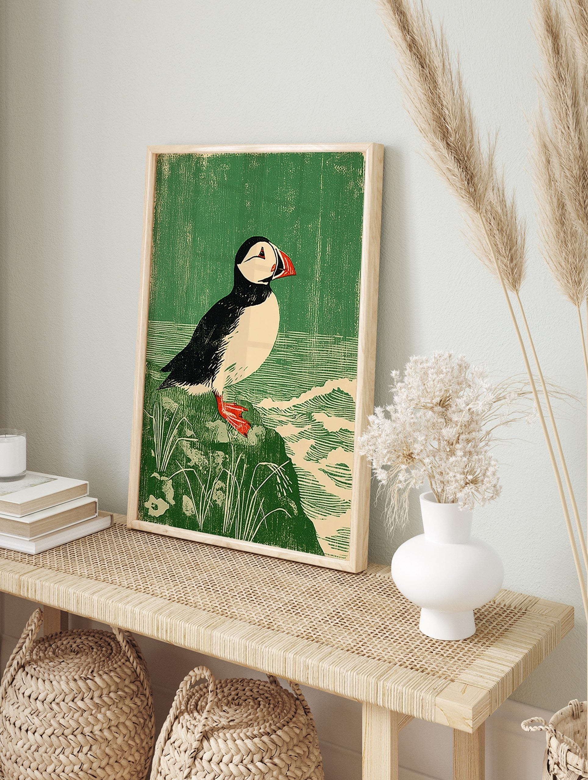 Atlantic Puffin bird print in linocut style on a rock with green background and waves, in an alternate framed mockup