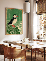 Atlantic Puffin bird print in linocut style on a rock with green background and waves, in a styled room mockup