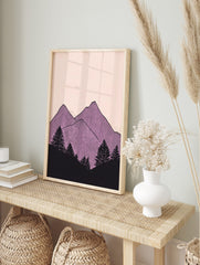 Illustrative purple mountain peaks with vertical lines and black pine trees on a pale pink, in an alternate framed mockup