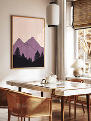 Illustrative purple mountain peaks with vertical lines and black pine trees on a pale pink, in a styled room mockup