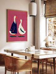 Illustrative art print of two white geese, one in a blue coat, against a textured pink background, in a styled room mockup
