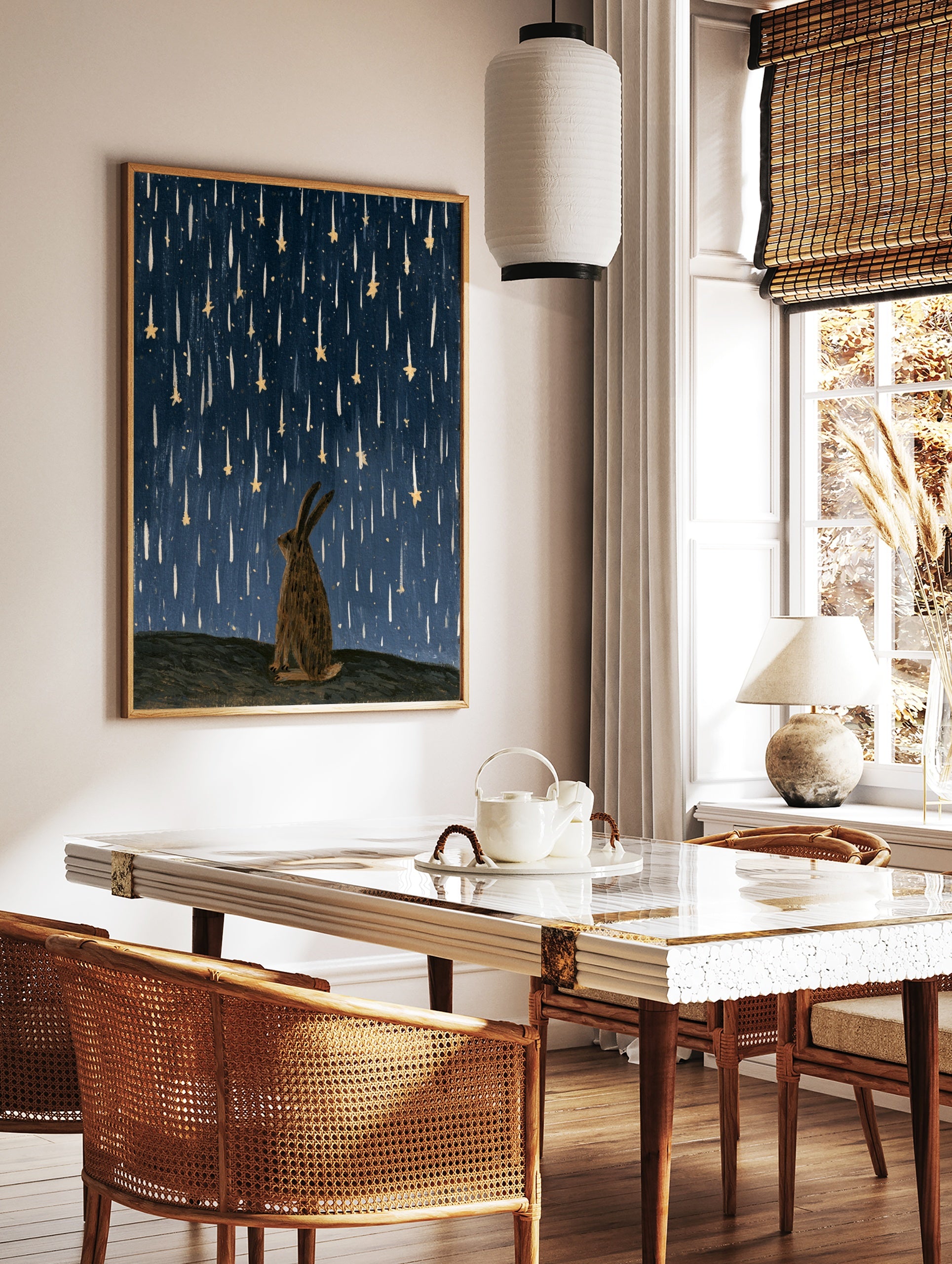 Illustrative rabbit silhouette gazing up at falling golden stars against a textured deep blue night, in a styled room mockup