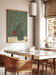 Illustrative woodcut style print of a grey rabbit holding a red lantern in the rain, dark green, in a styled room mockup