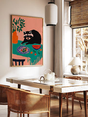 Illustrative art print of a raccoon looking at a plate of food and watermelon on a teal tablecloth, in a styled room mockup