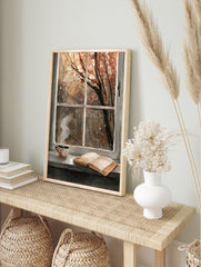 Illustrative autumn window scene with a coffee cup and open book on a rainy day, warm brown, in an alternate framed mockup