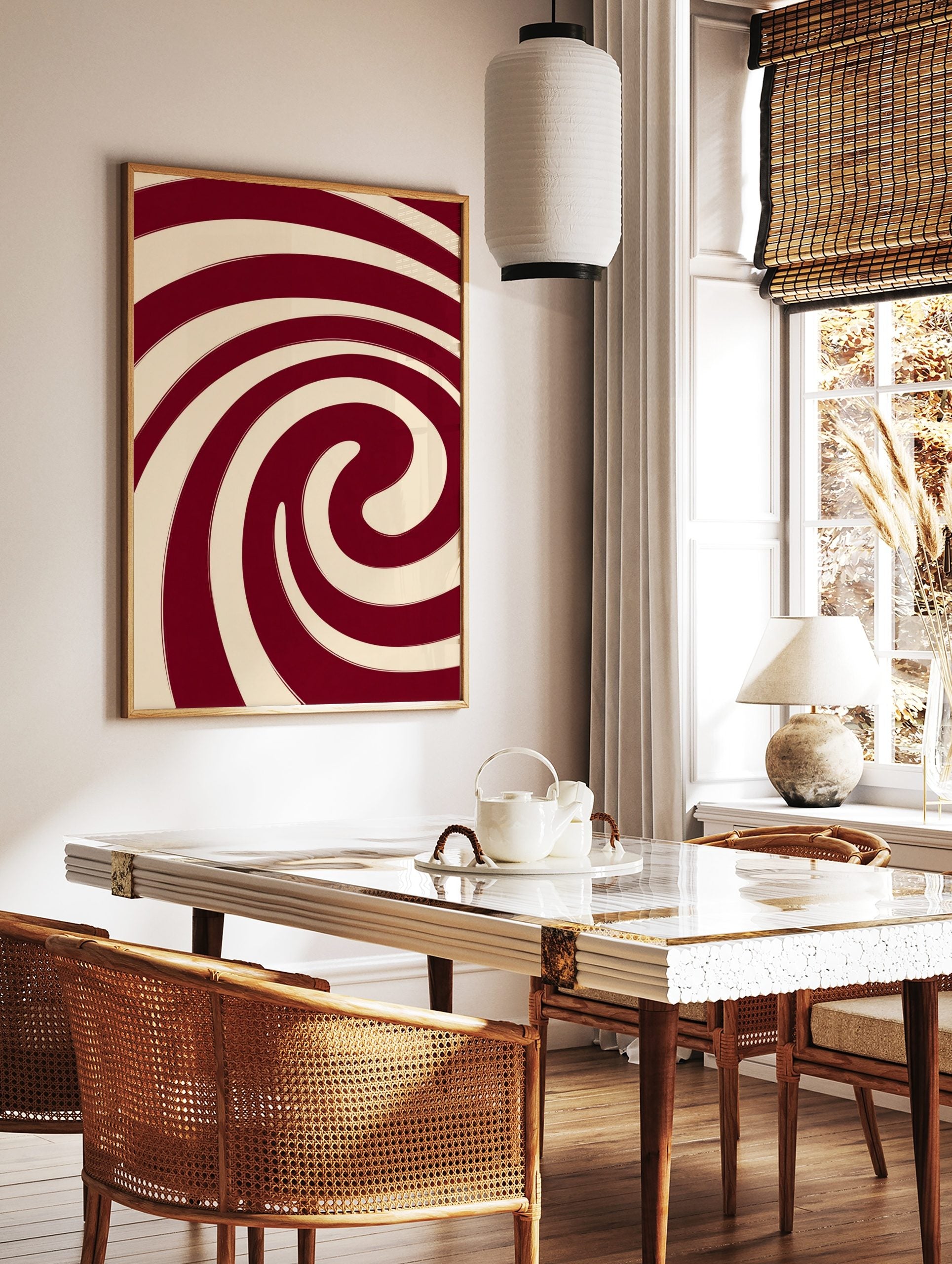 Abstract red and cream spiral wall art with bold, swirling lines and a hypnotic composition, in a styled room mockup