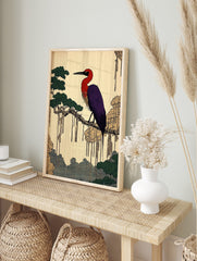 Japanese illustrative print of a red and purple heron on a tree branch with green foliage and, in an alternate framed mockup