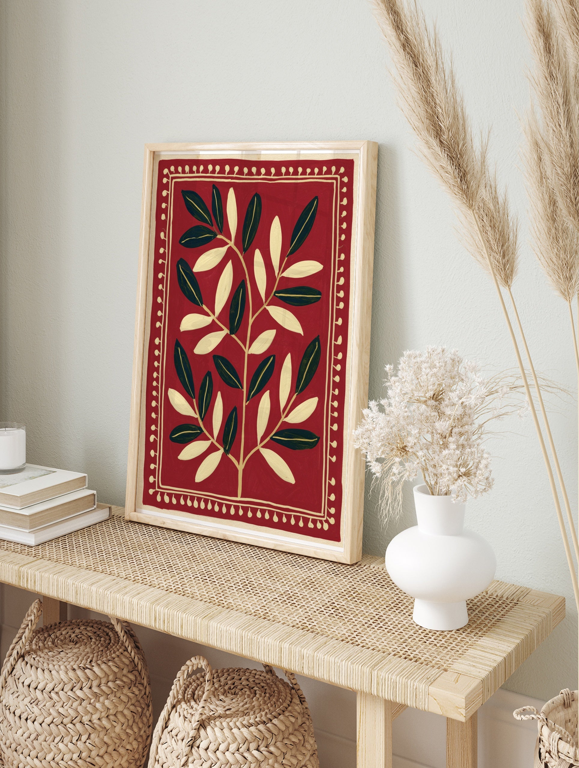 Symmetrical botanical leaf illustration in cream on a deep red background with a decorative, in an alternate framed mockup