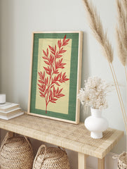 Red botanical illustration of a leafy stem on a pale beige panel, framed by a textured green, in an alternate framed mockup