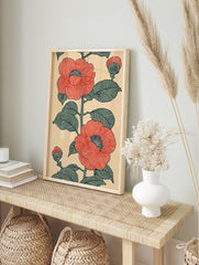 Red camellia botanical illustration with green leaves and buds on a beige background, in an, in an alternate framed mockup