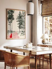 Illustrative print of a red cat on a striped path, looking into a forest clearing framed by green, in a styled room mockup