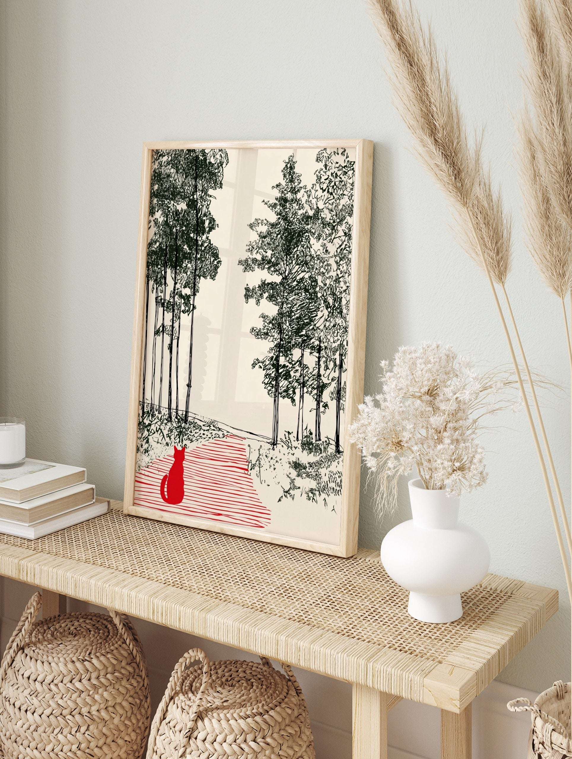 Illustrative print of a red cat on a striped path in a dark green forest on a cream background, in an alternate framed mockup