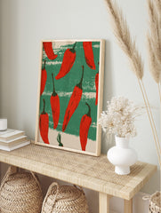 Illustrative red chilli peppers pattern on distressed green and beige striped background wall, in an alternate framed mockup