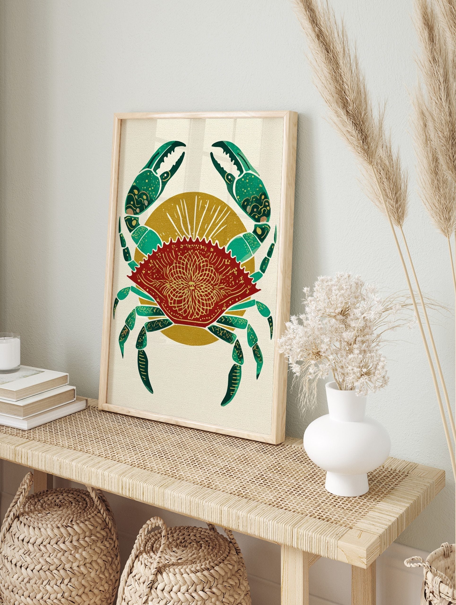 Red crab illustration with green claws and gold mandala pattern on shell, against a golden, in an alternate framed mockup