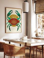 Red crab illustration with green claws and gold mandala pattern on shell, against a golden sunburst, in a styled room mockup