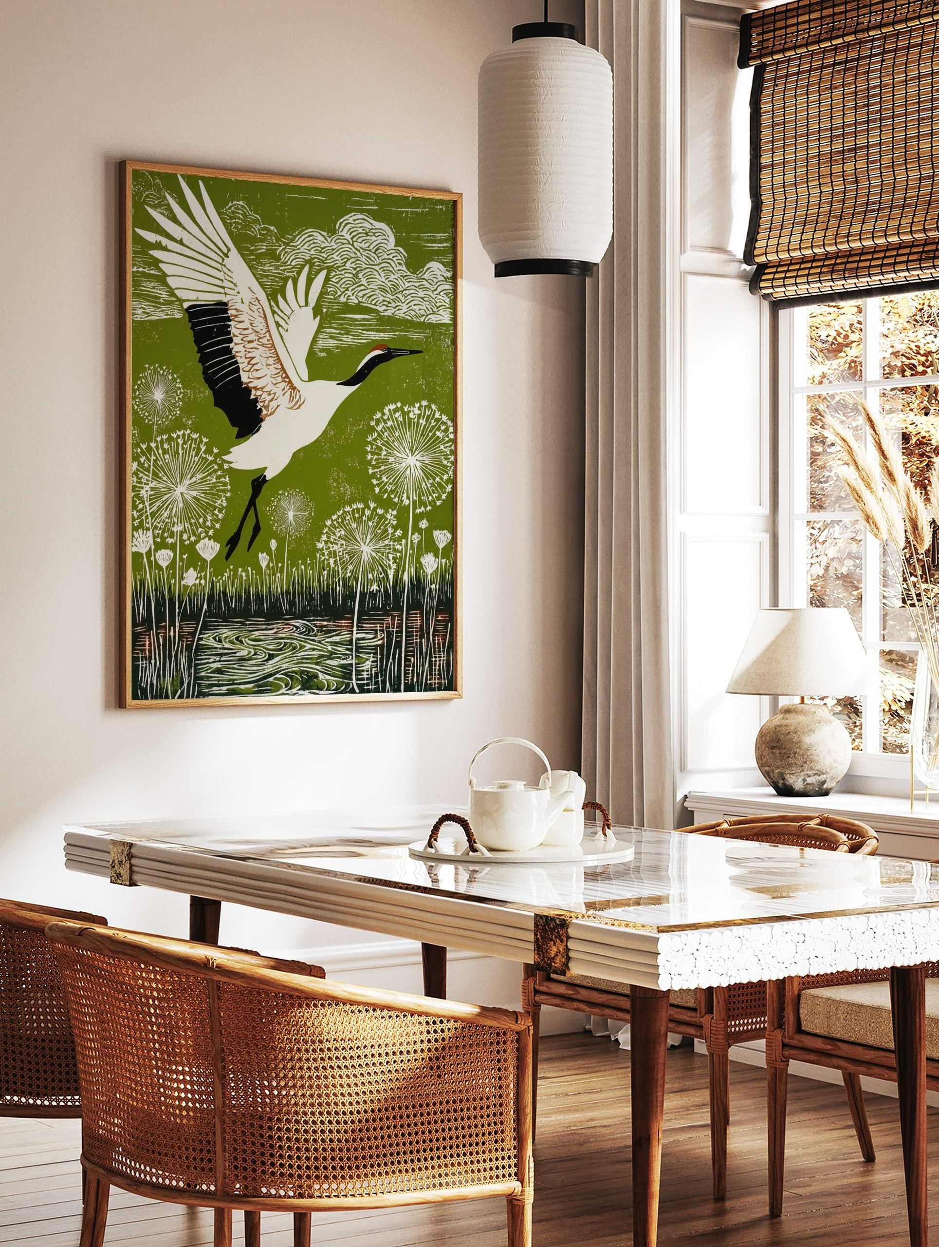 Red-crowned crane in flight over green landscape with white dandelion seed heads and water, in a styled room mockup
