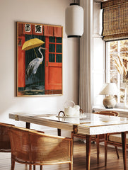 Red-crowned crane holding a yellow umbrella in rain outside a red Japanese building illustration, in a styled room mockup