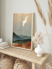 Red-crowned crane flying over misty blue mountains and autumn reeds in a Japanese-style art, in an alternate framed mockup