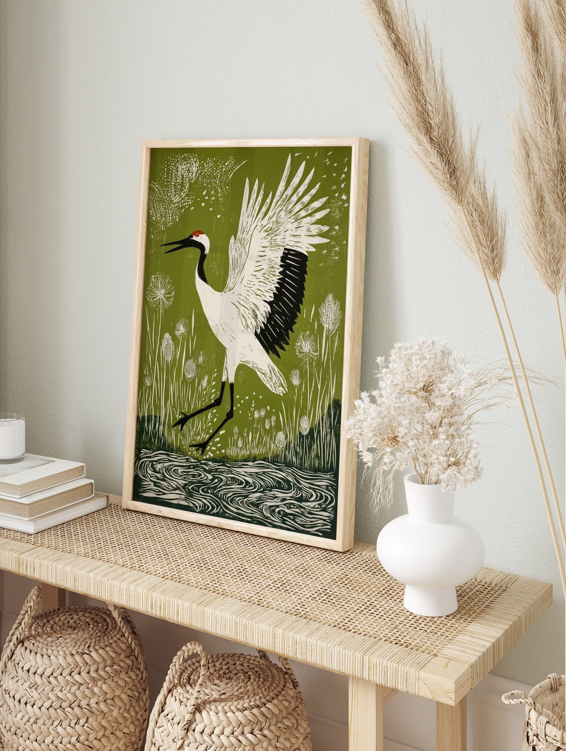 Linocut style print of a white red-crowned crane with black markings and red crown, wings, in an alternate framed mockup