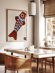 Stylized red fish illustration with blue scales and an ink signature, minimalist art print on, in a styled room mockup