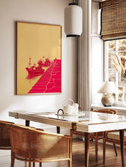 Red illustrative print of three fishing boats docked by a pier with a figure, against a beige, in a styled room mockup