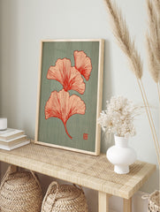Illustrative red Ginkgo leaves botanical print on a textured teal background with a small red, in an alternate framed mockup