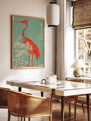Red heron with long beak and crest, against a teal background with white tree branches and Japanese, in a styled room mockup