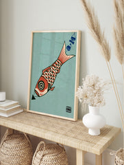 Graphic illustration of a red koi fish with a circular eye and scale pattern on a teal, in an alternate framed mockup