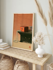 Still life art print of a red lacquer box and pearl necklace on a wooden table with a red, in an alternate framed mockup