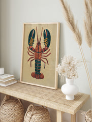 Illustrative red lobster wall art print with dark teal claws and orange spots on a light, in an alternate framed mockup
