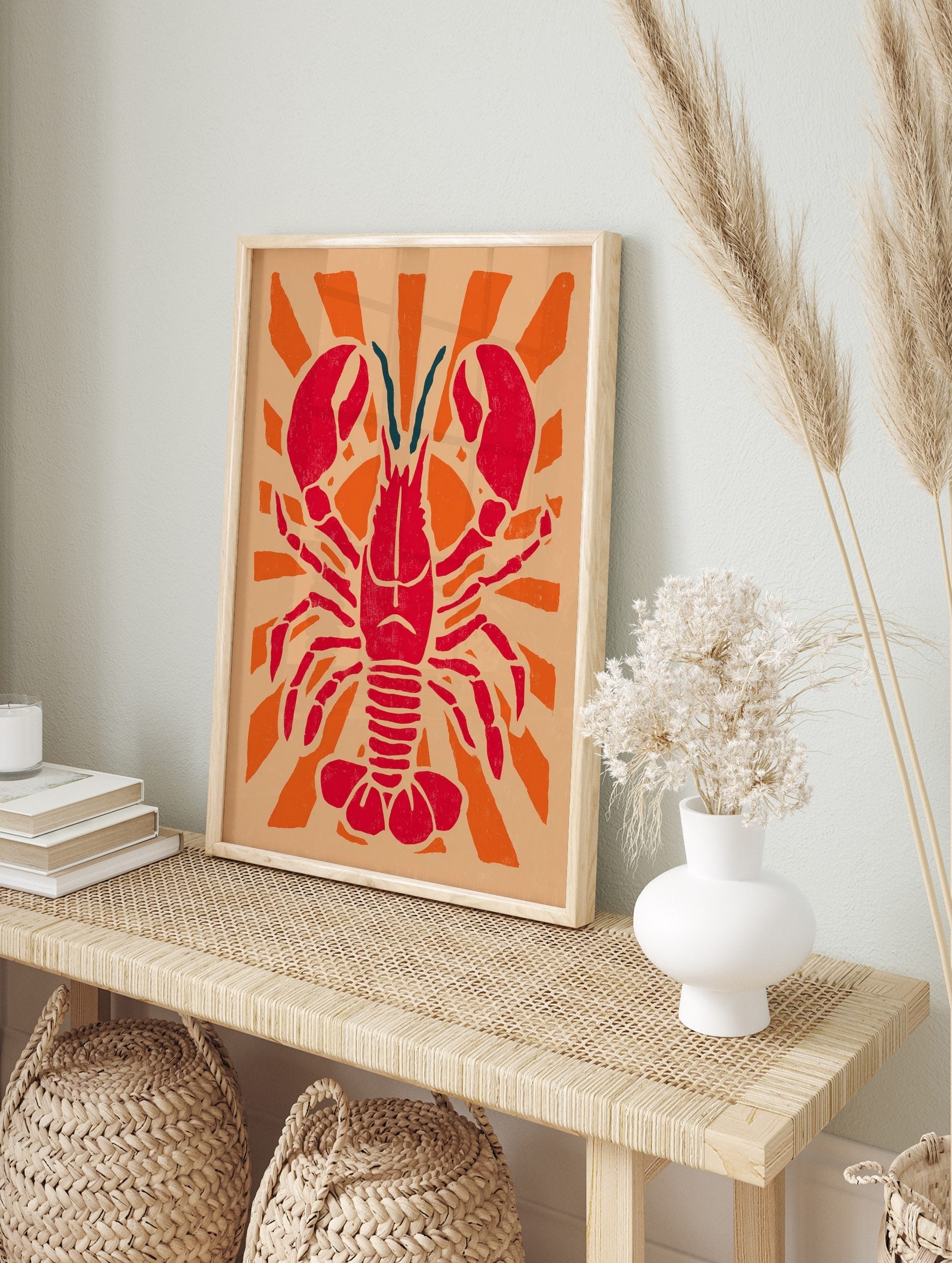 Red lobster illustration with large claws and teal antennae, centered on an orange sunburst, in an alternate framed mockup
