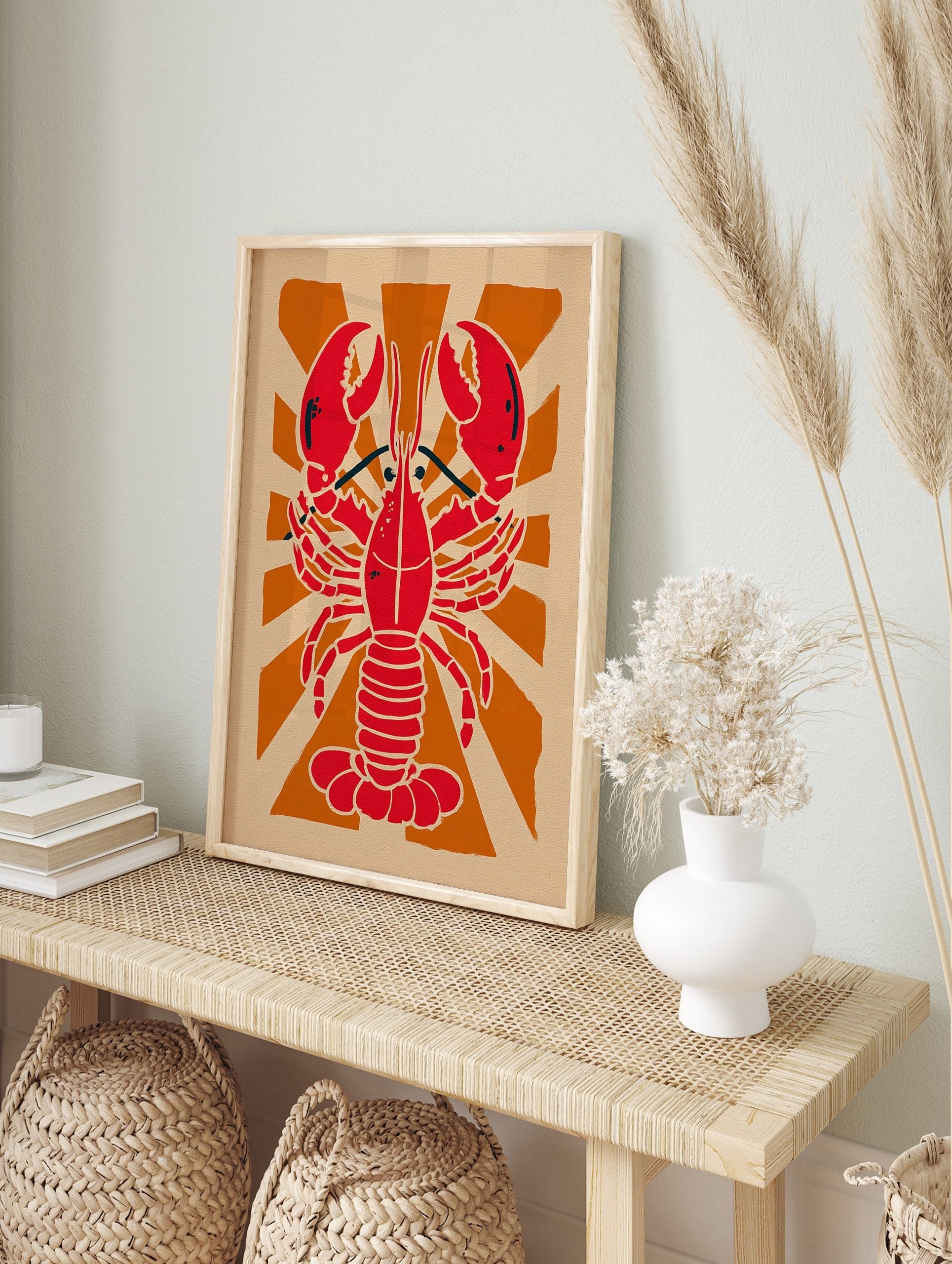 Red lobster illustration against an orange sunburst background on beige paper in a graphic, in an alternate framed mockup