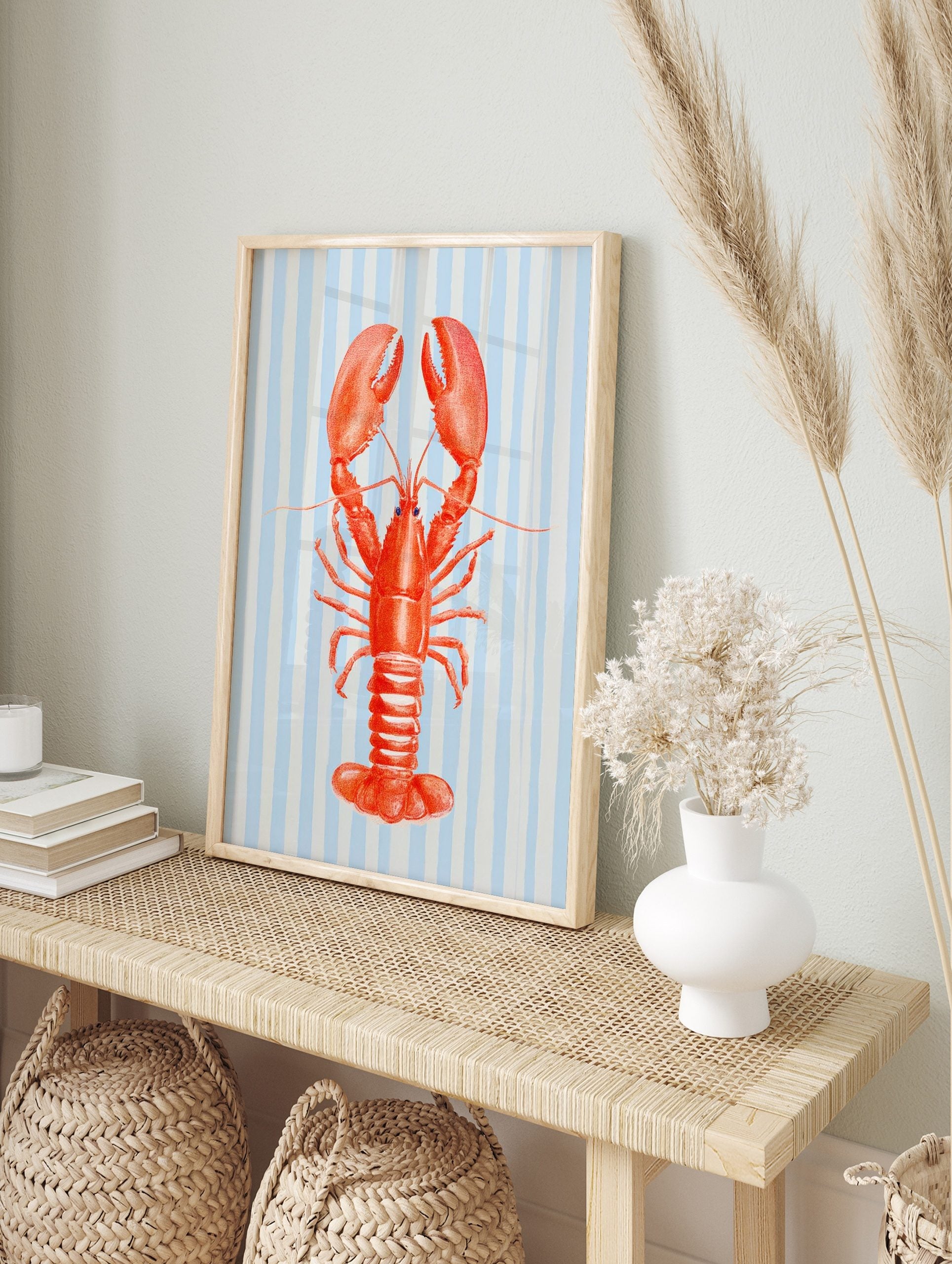 Red lobster illustration with large claws on a light blue and white striped background, in an alternate framed mockup