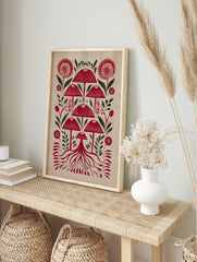 Red mushroom and botanical folk art print with stylised flowers, leaves, and roots on a light, in an alternate framed mockup