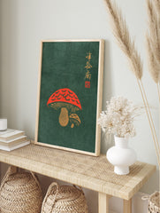 Red mushroom illustration with gold Japanese calligraphy on a dark green background, in an alternate framed mockup