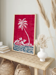 White palm tree and crashing waves illustration on a red background with blue and beige ocean, in an alternate framed mockup