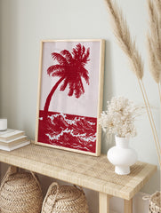 Red palm tree and ocean waves art print in an illustrative, high-contrast two-tone style, in an alternate framed mockup