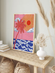 Red palm tree and golden sun over stylised blue ocean waves against a pink sky, illustrative, in an alternate framed mockup