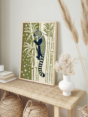 Illustrative red panda climbing bamboo art print with dark navy and cream fur, olive green, in an alternate framed mockup
