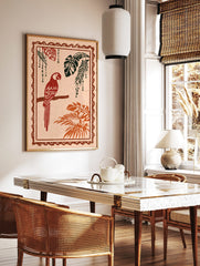 Red parrot illustration perched on a branch with tropical monstera and palm leaves, distressed style, in a styled room mockup