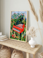 Illustration of a bright red grand piano sitting in a field of wildflowers with flowers, in an alternate framed mockup
