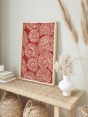 Repeating pattern of white spiralling nautilus shells on a deep red background, illustrative, in an alternate framed mockup