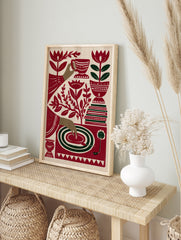 Stylized red and green illustrative art print of a tea cup, hand, record player, and flowers, in an alternate framed mockup