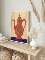 Red teapot wall art with green ornate patterns and a blue decorative base on a beige, in an alternate framed mockup