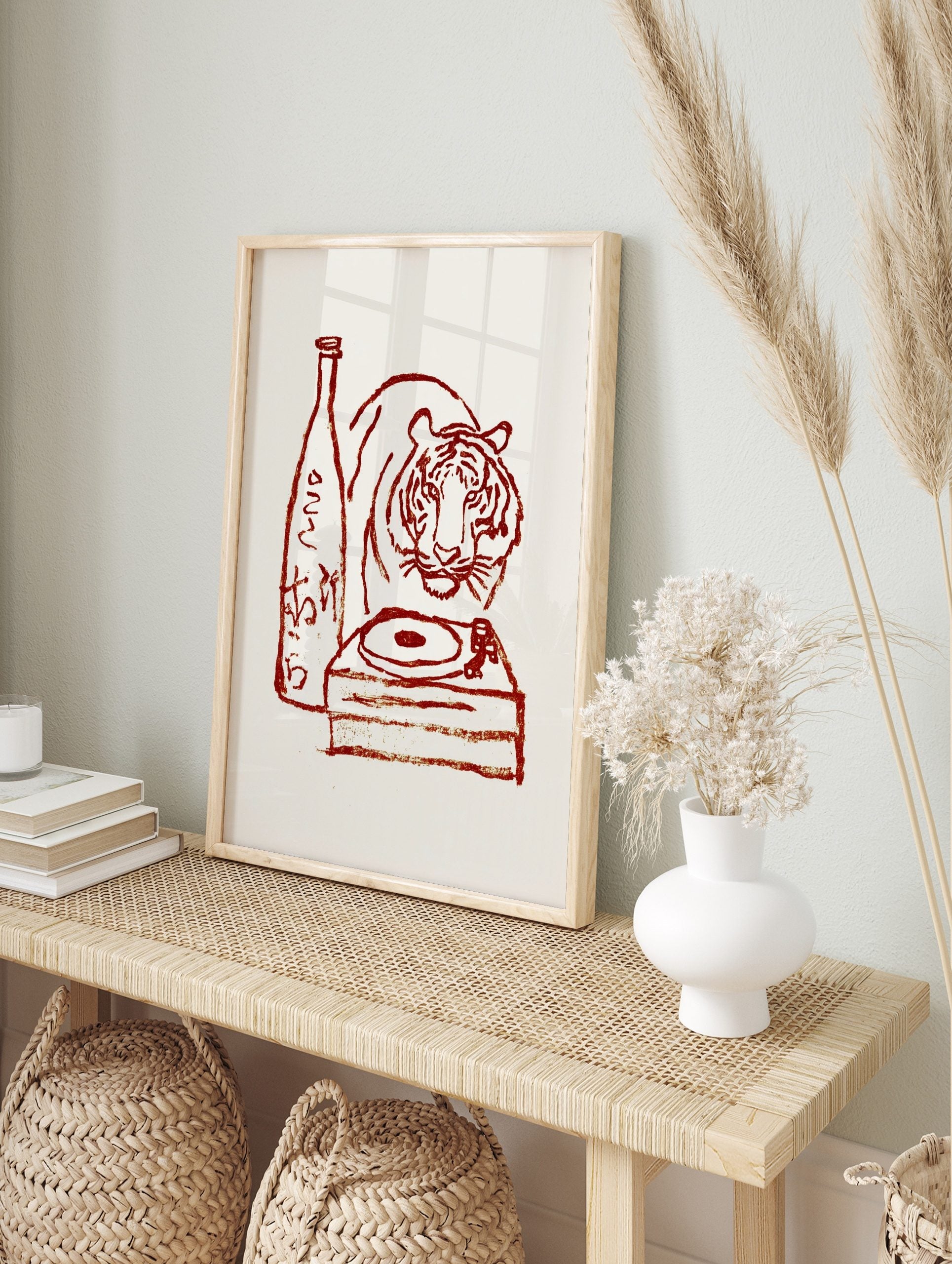 Red illustrative print of a tiger, sake bottle with Japanese text, and a turntable on a cream, in an alternate framed mockup