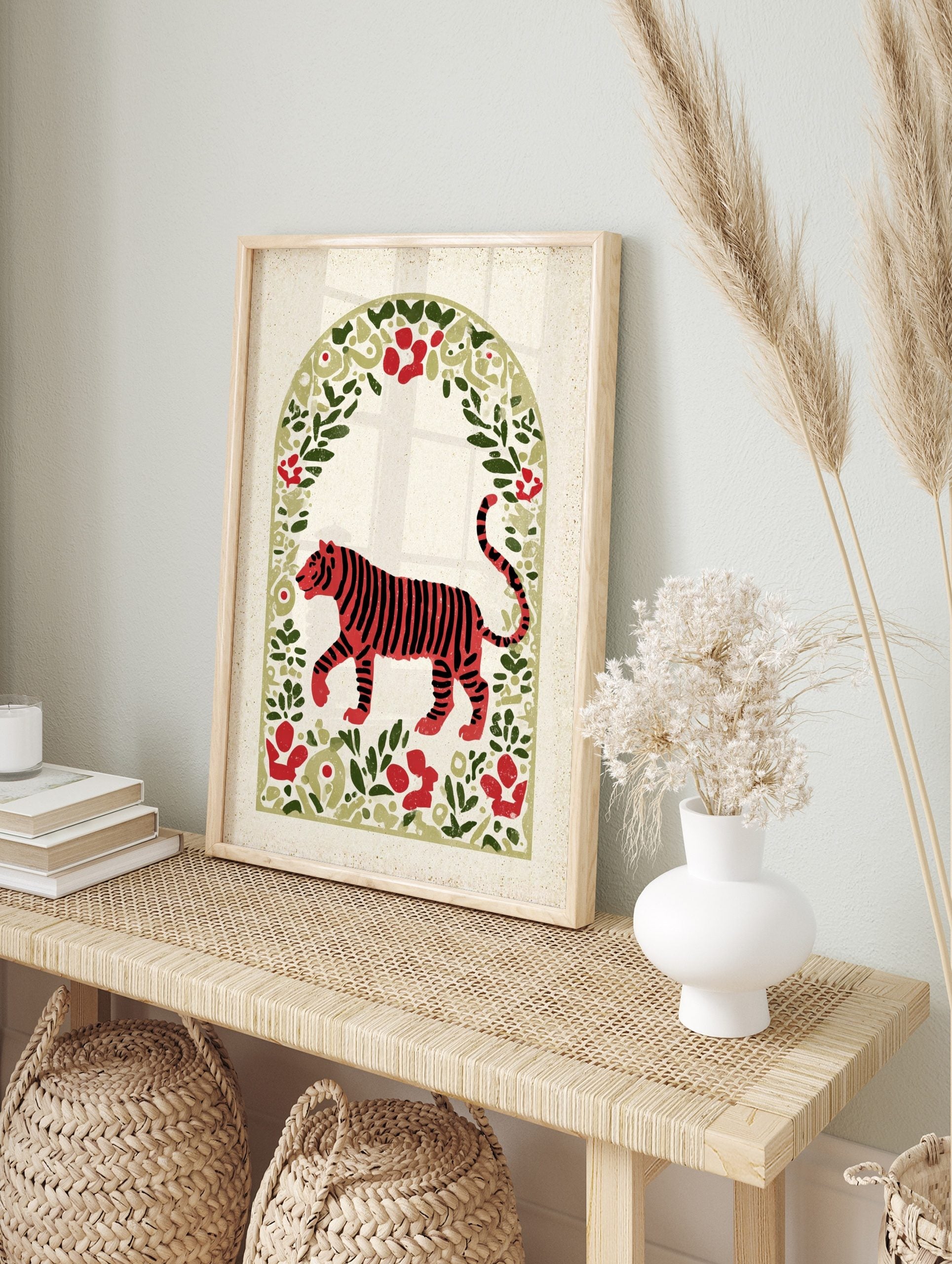 Red tiger illustration with black stripes, walking in an arched frame of green leaves and red, in an alternate framed mockup