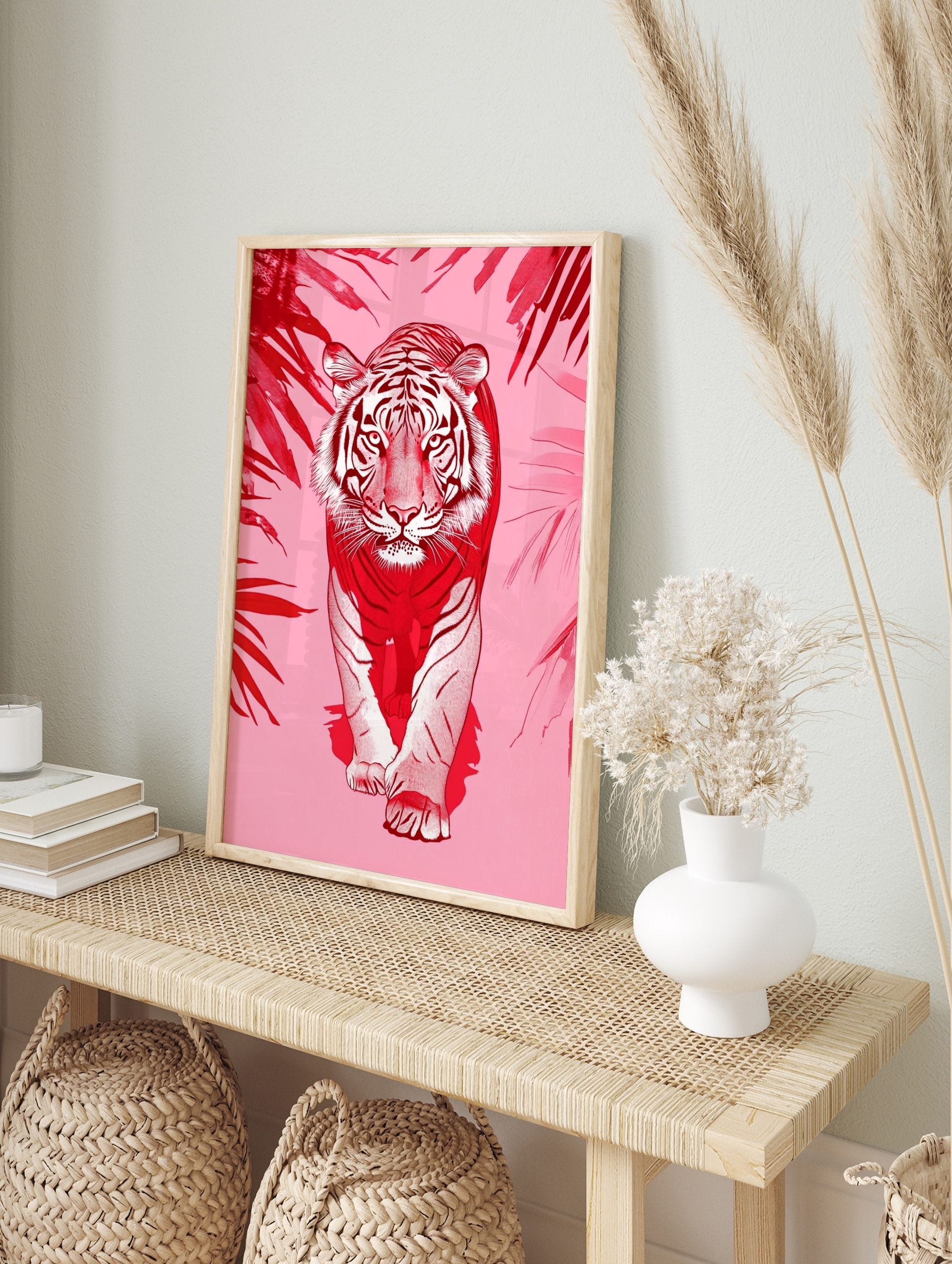 Red and white illustrative tiger walking forward, framed by red tropical leaves on a pink, in an alternate framed mockup