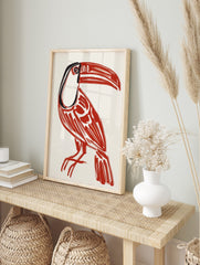 Bold red toucan bird illustration art print with black details on a cream background, in an alternate framed mockup
