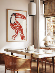 Bold red toucan bird illustration art print with black details on a cream background, portrait, in a styled room mockup